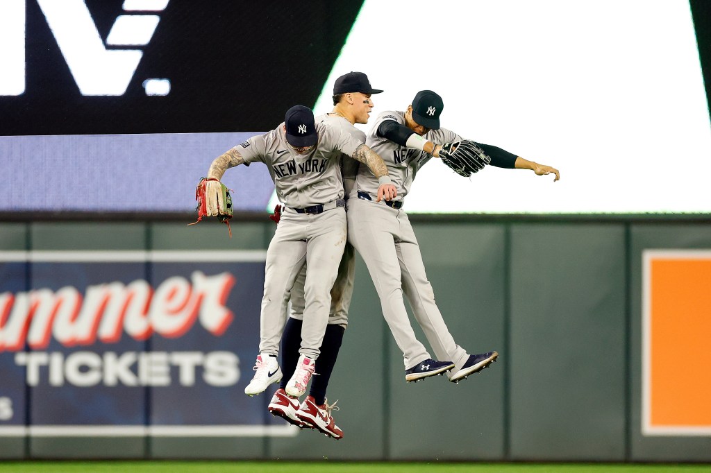 Alex Verdugo #24, Aaron Judge #99, and Juan Soto #22 of the New York Yankees celebrate their victory against the Minnesota Twins after the game at Target Field on May 15, 2024 in Minneapolis, Minnesota. The Yankees defeated the Twins 4-0.