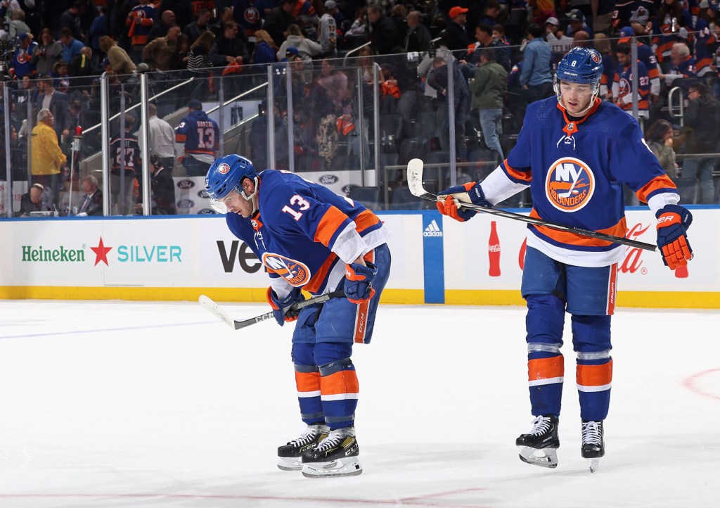 Mathew Barzal #13 and Noah Dobson #8 of the New York Islanders leave the ice following a loss to the Carolina Hurricanes in Game Three of the First Round of the 2024 Stanley Cup Playoffs at UBS Arena on April 25, 2024 in Elmont, New York. The Hurricanes defeated the Islanders 3-2.