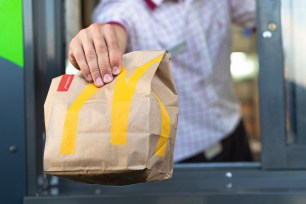 McDonald's worker in Sankt-Petersburg, Russia handing a bag of fast food through the drive-thru window on July 21, 2019