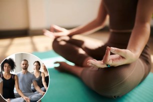 A person sitting on a yoga mat meditating with a man in the background